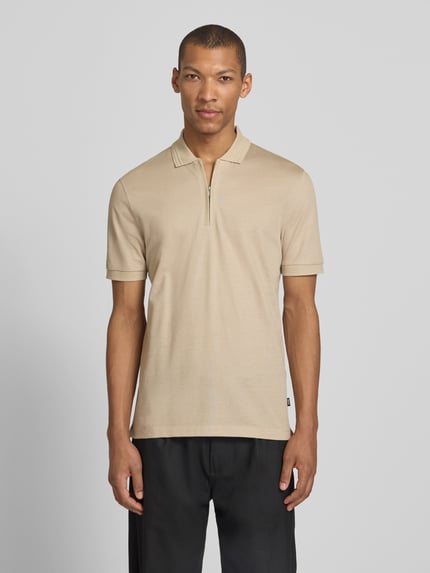 Männermodel trägt Regular Fit Poloshirt aus Baumwoll-Lyocell-Mix Modell 'H-PARAS 70' von BOSS in Beige, unifarben, Ganzkörperansicht von vorne.
