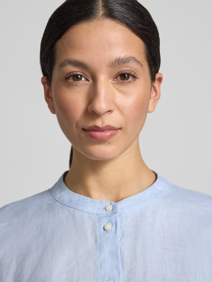 Frauenmodel trägt Bluse aus Leinen mit Trompetenärmeln Modell 'Fulis' von OPUS in Hellblau, Mao-Kragen, Knopfleiste, Nahaufnahme Oberkörper.