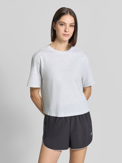 Frauenmodel trägt Relaxed Fit T-Shirt aus Baumwoll-Mix von Fabletics in Hellgrau, elastischer Stoff, mit Rundhalsausschnitt, Kurzarm, Ganzkörperansicht von vorne.