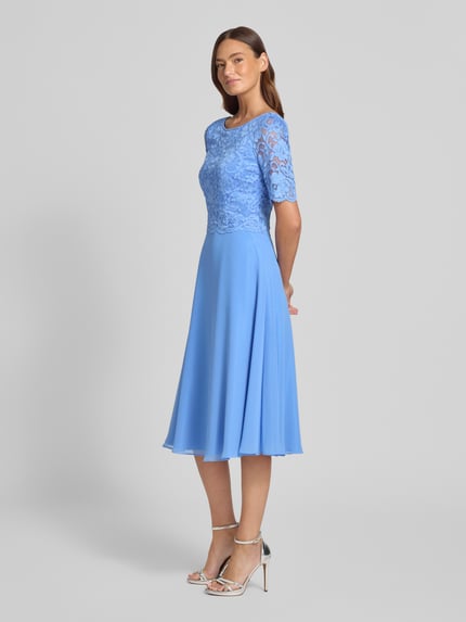 Vrouwenmodel draagt knielanges Cocktailjurk met kant en ronde halsuitsnijding van Vera Mont in blauw chiffon, a-lijn, ruglengte maat 36: 105 cm, borstwijdte maat 36: 40 cm, mouwlengte maat 36: 28 cm. Volledige lichaamsvooraanzicht.