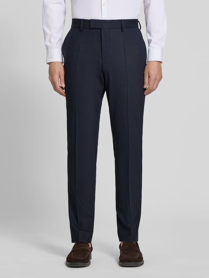 Mężczyznamodel nosi Slim Fit Anzug mit Schurwoll-Anteil Modell 'HUGE' von BOSS, ciemnogranatowy, subtelna faktura, spodnie z kantem, boczne kieszenie, widok z przodu, detalizacja: krój slim fit, marynarka z rozcięciami, dwurzędowe zapięcie, spodnie z zapięciem na haftkę i kryty zamek, długie rękawy, guziki kissing, kieszeń na piersi, kieszenie z patką, tylne kieszenie spodni, całkowity widok dolnej części sylwetki, Ganzkörperansicht von vorne.