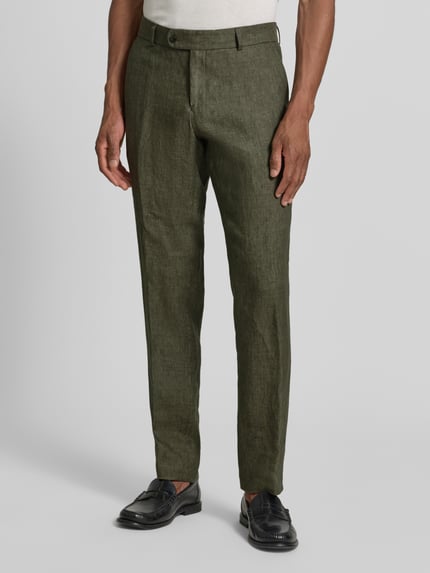 Männermodel trägt Slim Fit Leinenhose aus reinen Leinen Modell 'Tomte' von Carl Gross, olivgrün, Bügelfalten, Gesäßtaschen, Knopf- und Reißverschluss, Bundweite 45 cm, Innenbeinlänge 84 cm, Ganzkörperansicht von vorne.