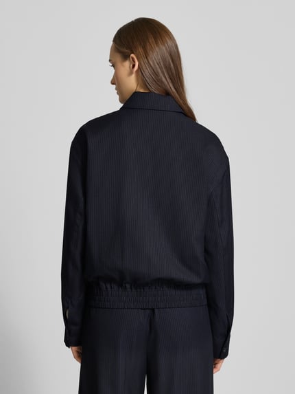 Vrouwenmodel draagt Lässige Blousonjacke mit Nadelstreifen van Review, materiaalmix met viscose, relaxed fit, krijtstreep, strookzakken, ritssluiting, ruglengte maat S 51 cm, schouderbreedte 44 cm, borstwijdte 48 cm, mouwlengte 47 cm, kleur donkerblauw, gestructureerde stof, geheel van achteren.