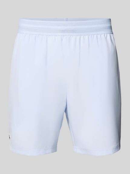 Produktfoto, hellblaue Loose Fit Sport-Shorts mit Mesh-Bund von Lacoste Sport, unifarben, elastischer Bund, seitliche Eingrifftaschen.