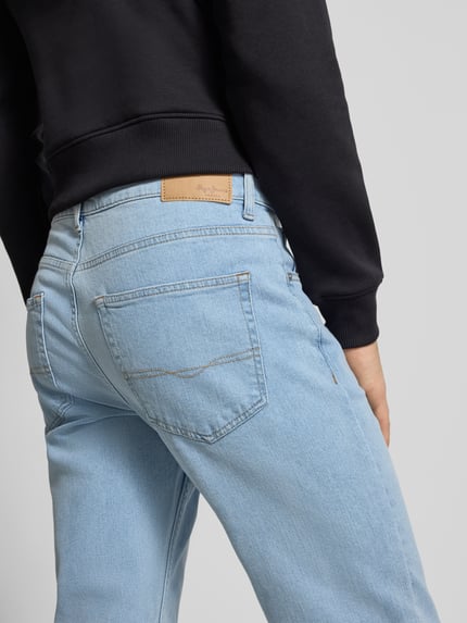 Männermodel trägt Straight Fit Jeans aus Baumwoll-Mix Modell 'CASH' von Pepe Jeans in Melange-Optik mit Label Patch, Ganzkörperansicht Rückansicht.