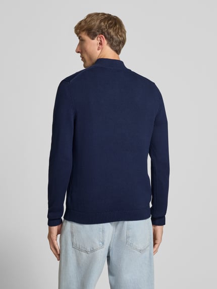 Männermodel trägt Slim Fit Strickpullover aus reine Baumwolle von REVIEW, dunkelblau, gerippte Abschlüsse, Rückenansicht, Ganzkörperansicht Rückansicht.