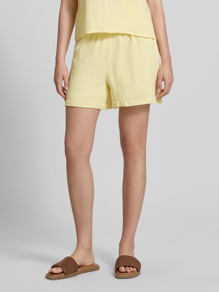 Vrouwenmodel draagt Comfort Fit Shorts uit puur katoen model 'SASTINA' van Pieces, look: effen, mousseline structuur, steekzakken, boord met tunnelkoord, kleur lichtgeel, Nahaufnahme onderlichaam.