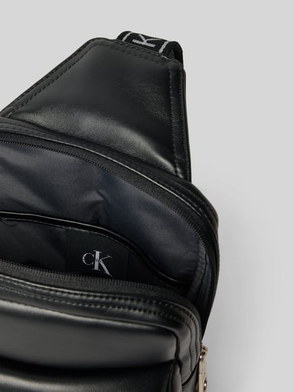 Produktfoto, czarna torba na ramię Herren Umhängetasche mit Label-Prägung od CK Calvin Klein, gładka faktura, srebrny zamek, widok z góry na otwartą kieszeń