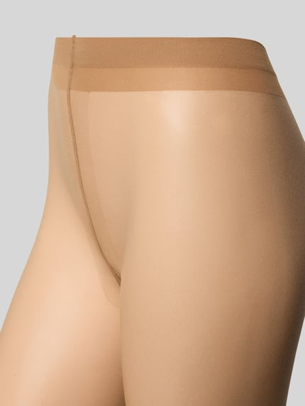 Vrouwenmodel draagt transparante panty met elastische band, nauwsluitende pasvorm, Transparente Strumpfhose Modell 'SHELINA 12 DEN' van Falke, detailopname heupen.