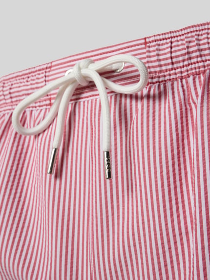 Productfoto, zwembroek met tunnelkoord model 'VELVETFISH' van BOSS, all-over streepmotief in rood-wit, elastische boord, steekzakken, achterzak, applicatie met labelstitching