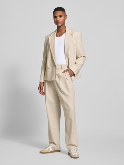 Mannelijk model draagt Relaxed Fit Stoffhose mit Gürtelschlaufen van JAKE*S STUDIO MEN in beige, met steekzakken en persplooien, broekriemlussen, knoop- en ritssluiting, zichtbare textuur, volledig lichaam van voren.