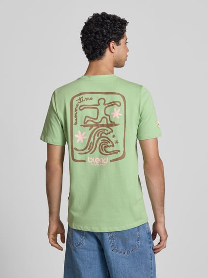 Männermodel trägt T-Shirt mit Motiv-Print Modell 'SUN SURF' von Blend, hellgrün, braun-rosa Print, Baumwolle, Regular Fit, Ganzkörperansicht Rückansicht