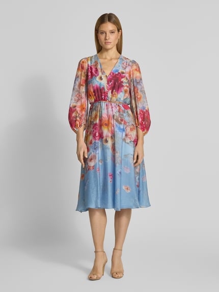 Frauenmodel trägt Cocktailkleid mit Bindegürtel von V by Vera Mont, Taillierter Schnitt, Midikleid, Allover-Look, V-Ausschnitt, Ganzkörperansicht von vorne.