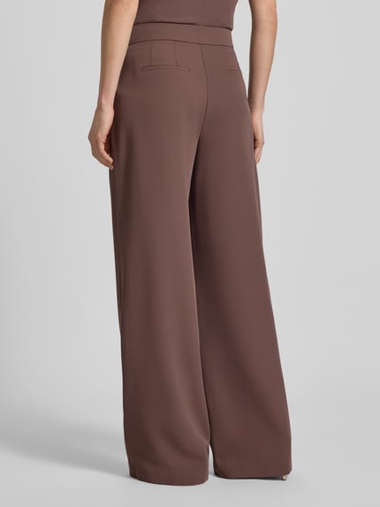 Vrouwenmodel draagt Wide Leg Stoffhose met Raffungen van Christian Berg Cocktail in bruin, elastische materiaalmix, wide leg, haken- en ritssluiting, plooien, bandwijdte maat 36: 38 cm, binnenbeenlengte maat 36: 82 cm, volledige lichaamsweergave achteraan.