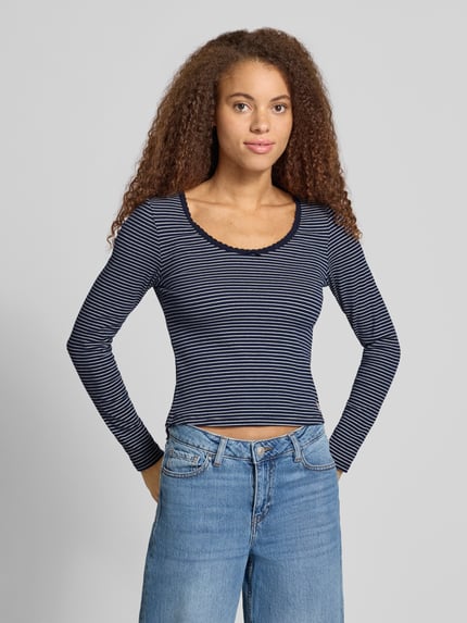 Frauenmodel trägt T-Shirt mit Rippstrickstruktur von LEVIS 300, gestreiftes Allover-Muster, U-Ausschnitt, cropped, Ganzkörperansicht von vorne.