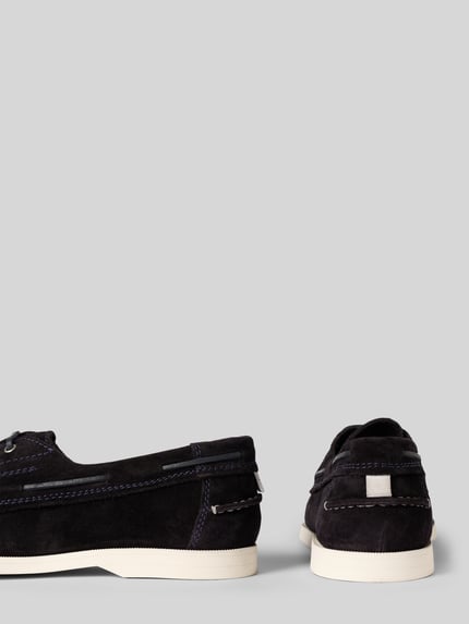 Produktfoto, Bootsschuhe mit Label-Stitching Modell 'Yardport' von Gant aus beschichtetem dunkelblauem Leder, strukturierte Sohle, abgerundete Form, Schnürung, Absatzhöhe 2 cm, Schafthöhe 7 cm, Schaftweite 14 cm, neutrale Farbgebung vor grauem Hintergrund.