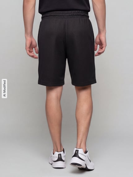 Männermodel trägt Relaxed Fit Sweatshorts aus Baumwoll-Mix 'ESS ELEVATED' von PUMA, Herren Sweatshorts, Ganzkörperansicht Rückansicht, KI-modifiziertes Bild.