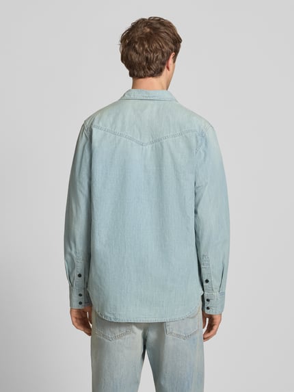 Männermodel trägt Regular Fit Freizeithemd mit Brusttaschen Modell 'dakota' von G-Star Raw im hellblauen Material-Mix, Ganzkörperansicht Rückansicht. Rückenlänge bei Größe M 78 cm, Schulterbreite 48 cm, Ärmellänge 66 cm, Kentkragen und Knopfleiste, Label-Detail.