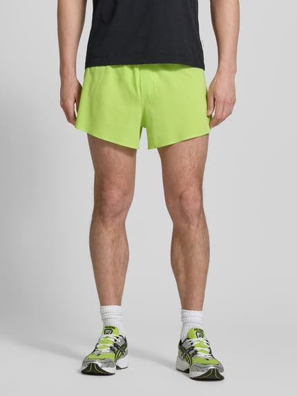 Männermodel trägt Shorts mit elastischem Bund Modell 'SENSE AERO' von Salomon aus Material-Mix mit Stretch-Anteil in Neongelb, Regular-Fit, Bundweite 38 cm, Innenbeinlänge 7 cm, Ganzkörperansicht von vorne.