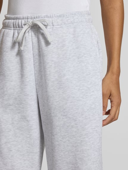 Frauenmodel trägt Regular Fit Sweathosemit Baumwoll-Anteil Modell 'BEST' von ONLY in Hellgrau mit weicher Textur, Nahaufnahme Oberkörper, Damen Sweathose von ONLY
