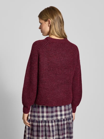 Frauenmodel trägt Relaxed Fit Strickpullover mit Woll-Anteil Modell 'GILA' von Only in Unifarbe, gerippte Abschlüsse, Ganzkörperansicht Rückansicht.