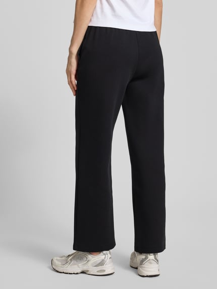 Frauenmodel trägt Sweatpants mit elastischem Bund und logo-print von ARMANI EXCHANGE, krój straight fit, wpuszczane kieszenie, czarny kolor, długość wewnętrzna nogawki w rozmiarze S: 72 cm, Ganzkörperansicht Rückansicht.