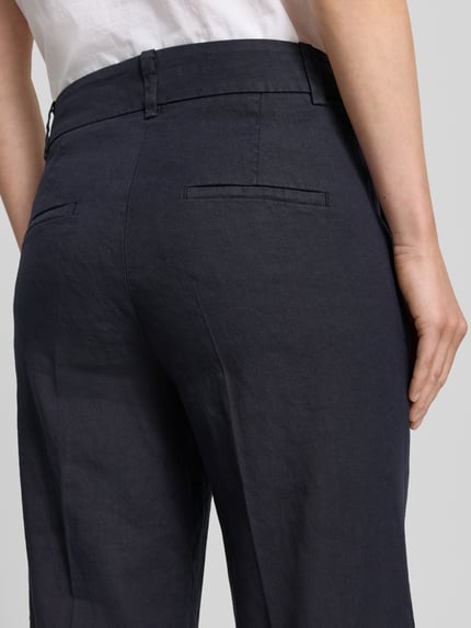 Frauenmodel trägt Chino aus Leinen-Mix mit Bügelfalte Modell 'CALIFORNIA' von Cambio, Gesäßtaschen, Ganzkörperansicht Rückansicht, Damen Chino, Leinen-Mix mit Baumwoll-Anteil, Straight Fit, Haken- und Reißverschluss, Französische Eingrifftaschen, Bundweite bei Größe 36: 41 cm, Innenbeinlänge bei Größe 36: 68 cm