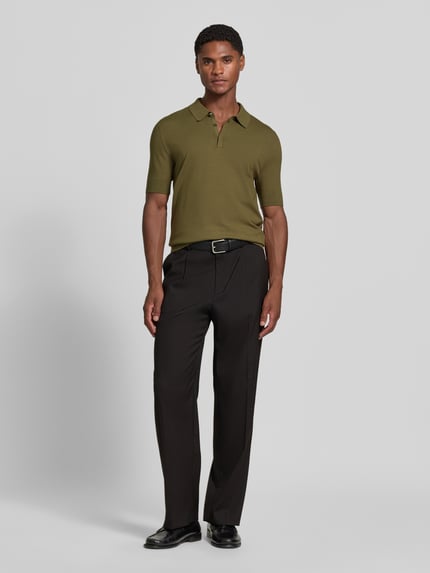 Męski model nosi Regular Fit Poloshirt aus Viskose-Mix model 'San Peter-CV' von HUGO, koszulka polo w kolorze oliwkowym, spodnie czarne, gładka tekstura, widok całej sylwetki z przodu, kontekst: koszulka polo męska od HUGO.