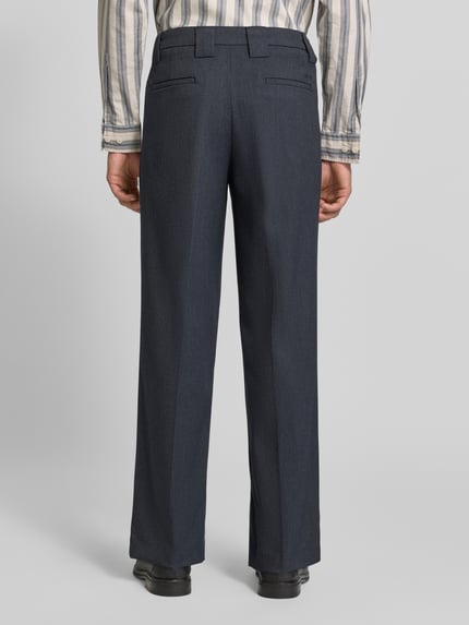 Männermodel trägt Straight Fit Stoffhose aus elastischem Viskose-Mix von MCNEAL in Dunkelblau mit Bügelfalten und Gürtelschlaufen, Ganzkörperansicht Rückansicht.