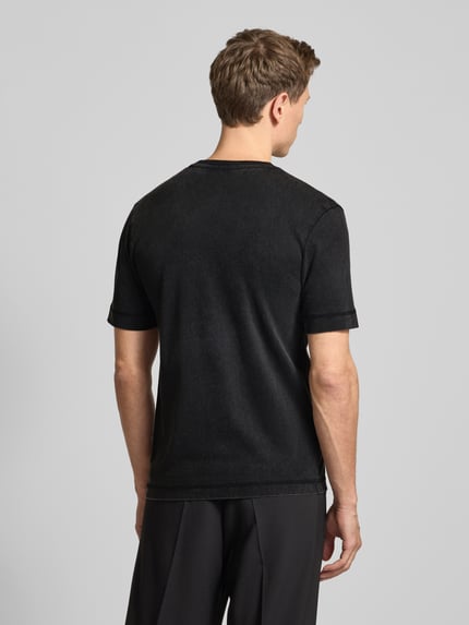 Männermodel trägt T-Shirt mit geripptem Rundhalsausschnitt von Drykorn in Schwarz, reine Baumwolle, Regular Fit, Rückenlänge 70 cm, Ganzkörperansicht Rückansicht.