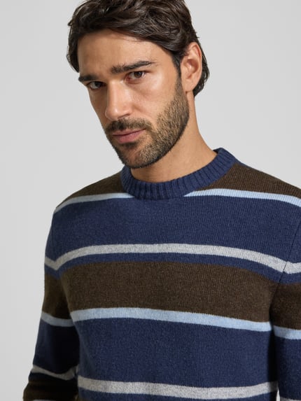 Männermodel trägt Strickpullover aus Woll-Mix im Allover-Look von MCNEAL, dunkle Blau- und Brauntöne, Nahaufnahme Oberkörper, Slim Fit, Rundhalsausschnitt.