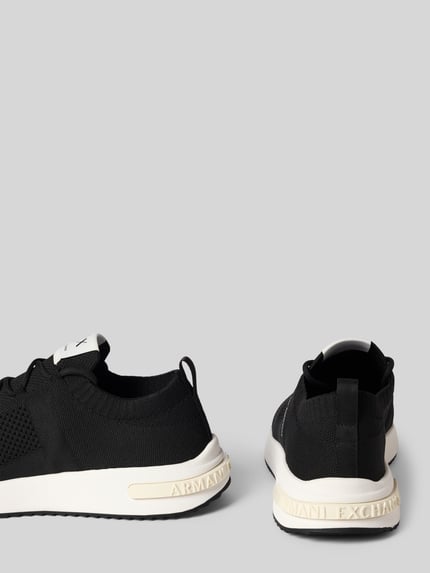 Produktfoto, Sneakersy w zakładanej przez głowę formie, model 'DUSSELDORF' od Armani Exchange, czarne, biała podeszwa, zaokrąglony czubek, detal z logo, wysokość obcasa 3 cm, wysokość cholewki 6 cm, szerokość w rozmiarze 45: 8 cm