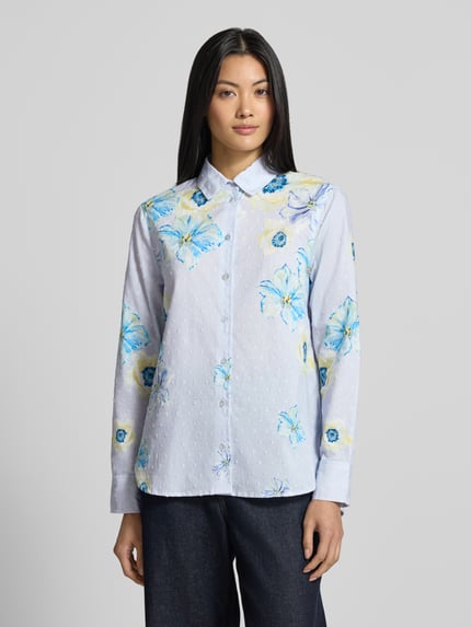 Vrouwenmodel draagt Regular Fit Hemdbluse aus reiner Baumwolle van Christian Berg Woman met all-over bloemenprint, met lange mouwen, overhemdkraag, puur katoen, ruglengte bij maat 36: 58 cm, mouwlengte bij maat 36: 61 cm, lichte en blauwe tinten, bloemenmotief, gestructureerde stof, voorkant volledige lichaamsopname.
