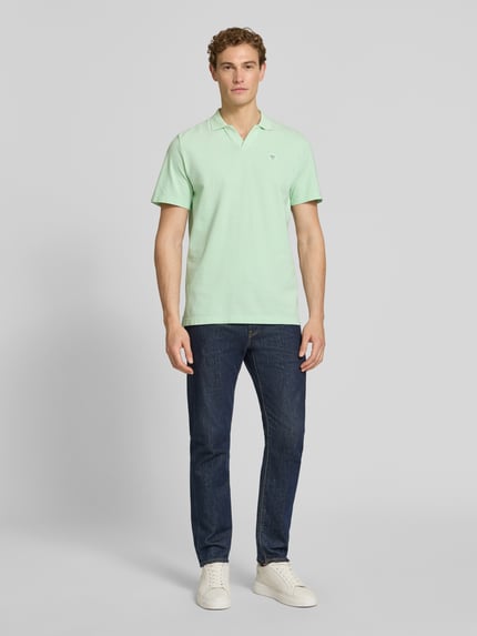 Męski model nosi Regular Fit Poloshirt aus reiner Baumwolle von s.Oliver RED LABEL, efekt: jednolity kolor, naszywka z logo, kołnierzyk polo, dekolt w serek, krótki rękaw, zakończenia rękawów prążkowane, wykończenie: boczne rozcięcia, wykończenie materiału: pika, materiał: bawełna, Ganzkörperansicht von vorne