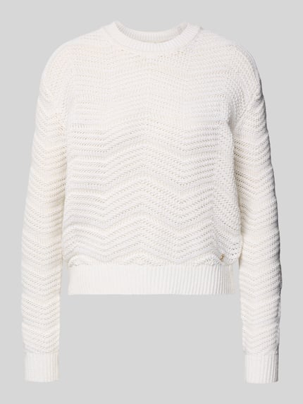 Produktfoto, cremefarbener Strickpullover mit gerippten Abschlüssen von Guess, lockerer Schnitt, Baumwoll-Mix, Rundhalsausschnitt, klare Struktur.