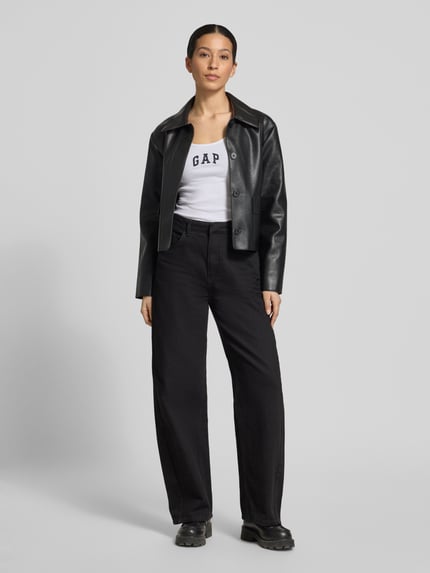 Vrouwenmodel draagt Slim Fit Top mit Logo-Print van GAP in wit, elastische katoenmix, slim fit, logo-opdruk, ronde hals, ruglengte 58 cm, full body frontaal.