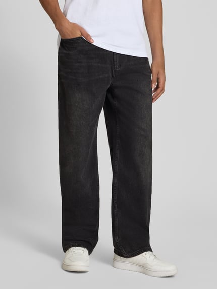Męski model nosi Baggy Jeans in schwarzer Waschung und klassischem 5-Pocket-Design von REVIEW, Mieszanka bawełny i elastanu, krój baggy, czarny kolor, zapięcie na guzik i zamek błyskawiczny, szerokość w rozmiarze 32: 42 cm, długość wewnętrzna nogawki w rozmiarze 32: 76 cm, stylizowana na denim, całkowita sylwetka z przodu.