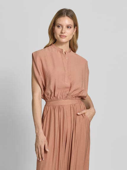 Frauenmodel trägt Cropped Blusentop mit Knopfverschluss von Style Icon Collection in Rosa, elastischer Bund, Rundhalsausschnitt, Rückenlänge 42 cm bei Größe 36, Nahaufnahme Oberkörper.