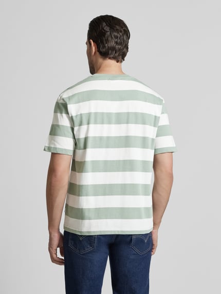 Männermodel trägt Oversized T-Shirt mit Rundhalsausschnitt von Lindbergh, Streifenmuster, Reine Baumwolle, Rückenlänge 67 cm, Ganzkörperansicht Rückansicht.