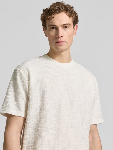 Mannelijk model draagt T-Shirt met structuurpatroon en ronde hals van MCNEAL, regular fit, katoenmix, crème, close-up bovenlijf.