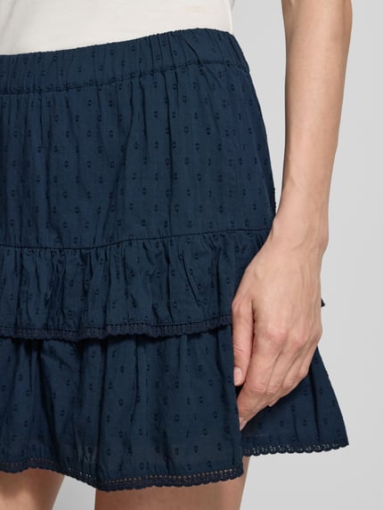 Frauenmodel trägt Volant Mini-Rock aus reiner Baumwolle 'TRINE' von Vero Moda in Optik: Unifarben, Muster: Gepunktet, Popeline, Nahaufnahme Oberkörper.