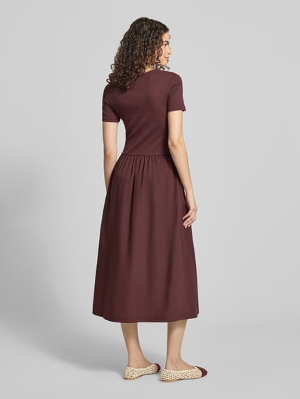 Frauenmodel trägt Slim Fit Freizeitkleid aus Baumwoll-Mix von Marc O'Polo DENIM in Dunkelrot, glatte Struktur, Ganzkörperansicht Rückansicht.