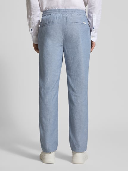 Männermodel trägt Jogpants aus Baumwoll-Leinen-Mix Modell 'WARREN' von Scotch & Soda in Hellblau, Regular-Fit, Ganzkörperansicht Rückansicht.