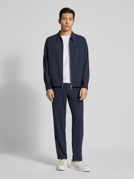 Männermodel trägt Modern Fit Hemdjacke mit Zweiwege-Reißverschluss von Lindbergh im Streifenmuster, Blautöne, Ganzkörperansicht von vorne.