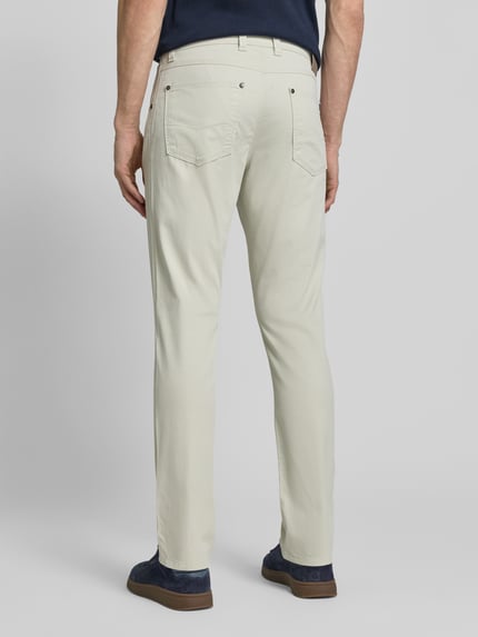 Männermodel trägt Regular Fit Hose mit Eingrifftaschen Modell 'CORDOBA' von bugatti aus Baumwoll-Elasthan-Mix, Ganzkörperansicht Rückansicht.
