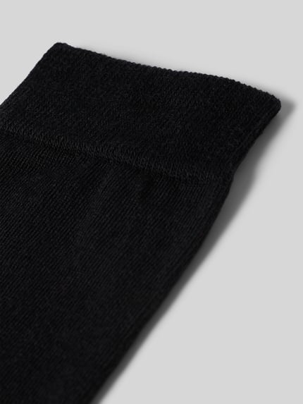 Produktfoto, czarne Socken mit Label-Schriftzug Modell 'SOFTMERINO' von FALKE z mieszanki wełny i bawełny z elastycznym ściągaczem, tekstura miękka.