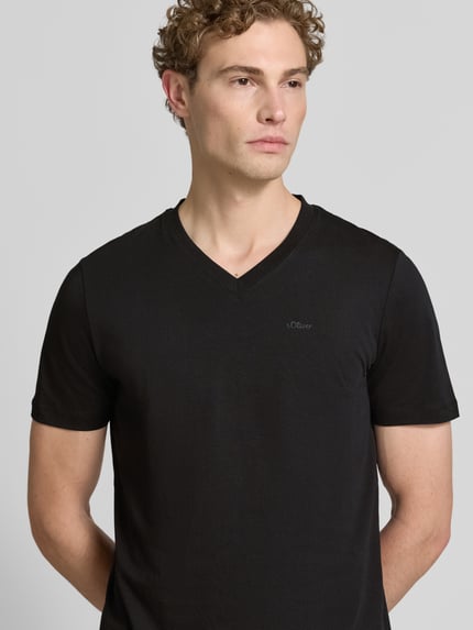 Männermodel trägt schwarzes Regular Fit T-Shirt aus reiner Baumwolle von s.Oliver RED LABEL, dezente T-Shirt-Optik, Nahaufnahme Oberkörper.