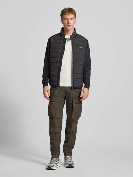 Männermodel trägt Regular Tapered Cargohose aus Baumwoll-Mix Modell 'Rovic' von G-Star RAW, olivgrün, unifarben, mit Cargotaschen, Ganzkörperansicht von vorne.