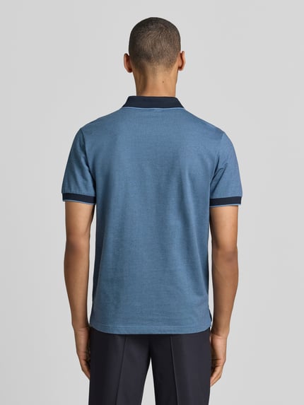 Männermodel trägt Regular Fit Poloshirt mit Logo-Stitching von Lerros in Blau mit Polokragen und kurzer Knopfleiste, Ganzkörperansicht Rückansicht.
