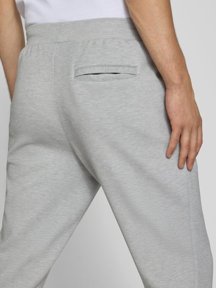 Mężczyznamodel nosi Regular Fit Sweatpants mit Lyocell-Anteil von PUMA PERFORMANCE, elastyczna mieszanka materiałów, detal z logo, elastyczny pas z tunelem, zakończenia nogawek: elastyczne, Długość wewnętrzna nogawki w rozmiarze M: 76 cm, szara, gładka faktura, detal kieszeni z tyłu, detal: kieszeń, Ganzkörperansicht Rückansicht